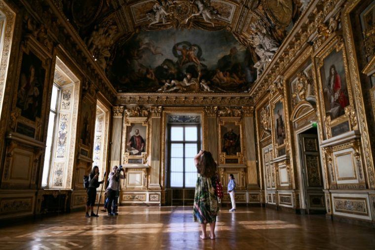 Des visiteurs prennent en photo la fenêtre par laquelle des cambrioleurs se sont introduits en octobre 2025 dans la galerie d'Apollon du musée du Louvre, lors de la réouverture des lieux, le 22 juillet 2026 à Paris ( POOL / LOU BENOIST )