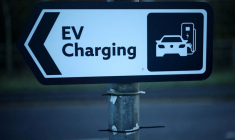 PHOTO D'ARCHIVES : Un panneau de signalisation pour les voitures est accroché à un lampadaire près d'une station de recharge pour véhicules électriques à Manchester.