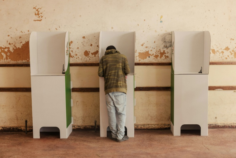 Un électeur dépose son bulletin dans un bureau de vote à Lusaka lors de l'élection présidentielle zambienne, le 13 août 2026 ( AFP / GIANLUIGI GUERCIA )