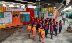 Des élèves chantent l'hymne national indien à "l'école du feu rouge" qui accueille des enfants défavorisés dans des conteneurs aménagés en salles de cours sous un pont autoroutier, le 18 mai 2026 à Bombay ( AFP / Punit PARANJPE )
