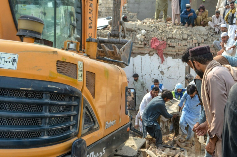 Des personnes transportent le corps d'une victime après un attentat contre un poste de contrôle de police à Bannu, dans le nord-ouest du Pakistan, le 10 mai 2026 ( AFP / Karim ULLAH )