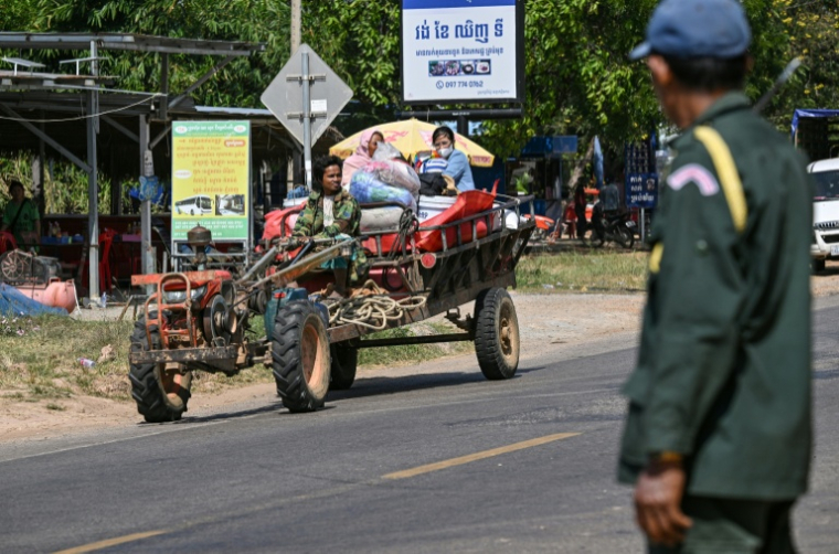 Un policier observe des résidents qui évacuent suite à des affrontements le long de la frontière entre le Cambodge et la Thaïlande dans la province de Siem Reap le 9 décembre 2025 ( AFP / TANG CHHIN SOTHY )