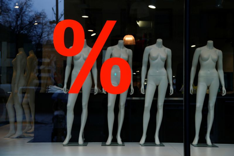 Un panneau de réduction est affiché dans la vitrine d'un magasin de vêtements à Francfort