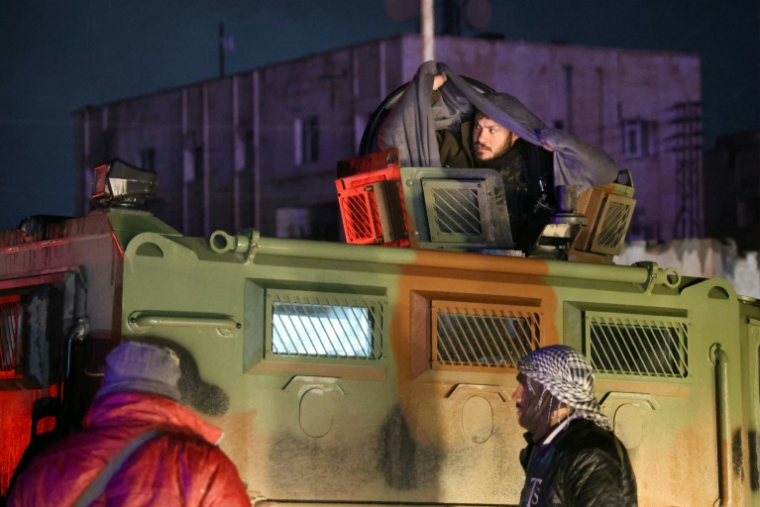 Des membres forces des Forces démocratiques syriennes (FDS) dirigées par les Kurdes se retirent de la prison d'al-Aqtan, à la périphérie de Raqa, à destination de Kobané, le 23 janvier 2026 en Syrie ( AFP / Bakr ALKASEM )