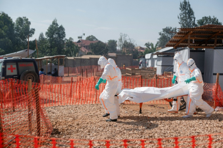 Des agents sanitaires transportent à la morgue du Centre médical évangélique de Nyankunde (RDCongo) le corps d’une personne décédée d'Ebola, le 13 juin 2026  ( AFP / Jospin Mwisha )