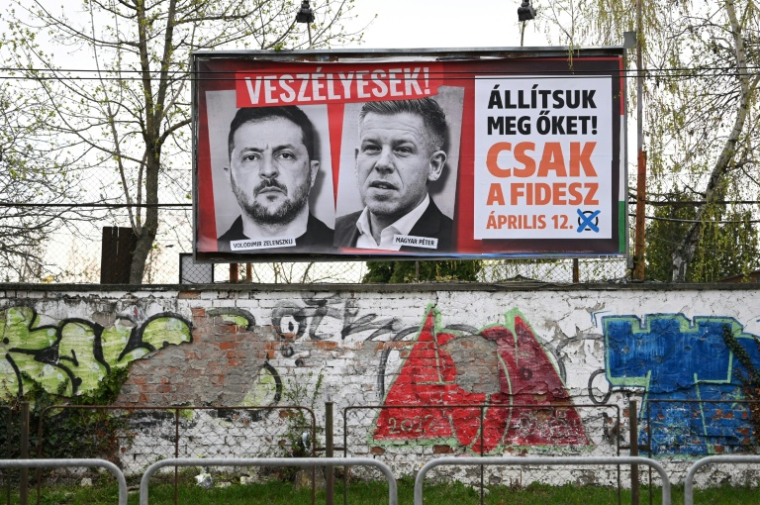 Une affiche progouvernementale présentant les portraits du président ukrainien Volodymyr Zelensky (g) et du chef de l'opposition hongroise Peter Magyar, avec les slogans "Ils sont dangereux" (en haut) et "Arrêtons-les, juste le Fidesz" (d), le 27 mars 2026  ( AFP / ATTILA KISBENEDEK )