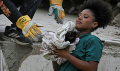 Une secouriste bénévole porte un chat sorti des décombres d'un immeuble détruit par les séismes du 24 juin à Caraballeda, au Venezuela, le 18 juillet 2026 ( AFP / Juan BARRETO )