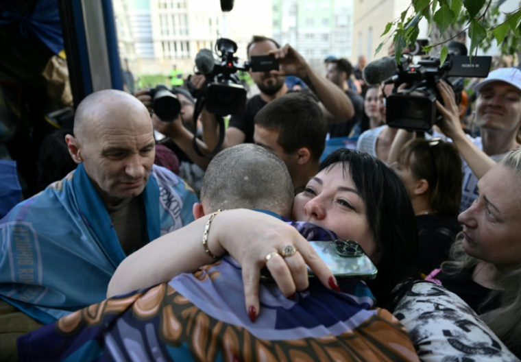 Un prisonnier ukrainien retrouve ses proches à son arrivée après un échange de prisonniers dans la région de Tcherniguiv, le 23 mai 2025 ( AFP / Genya SAVILOV )