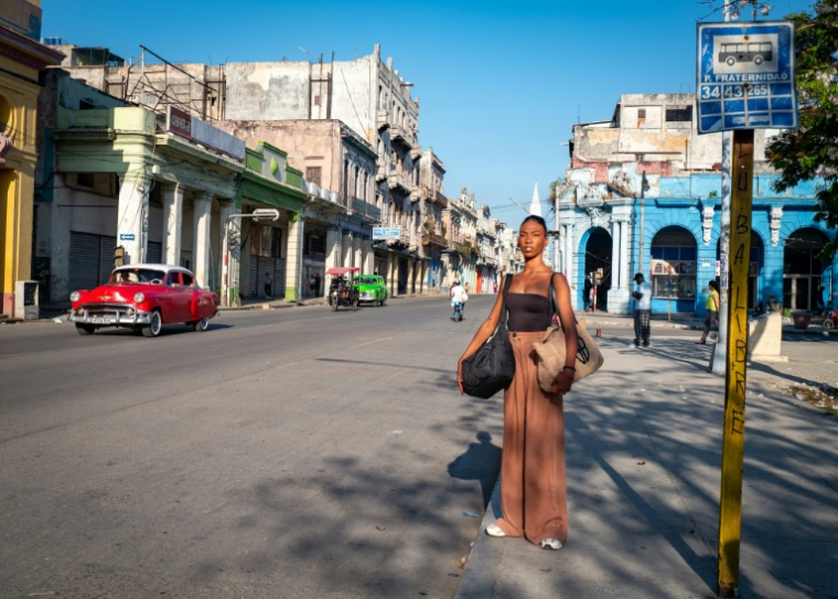 La danseuse Laura Kamila Rojas attend un bus dans une rue de La Havane pour se rendre au Ballet national de Cuba, le 12 mai 2026 ( AFP / ADALBERTO ROQUE )