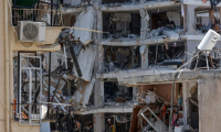 Des secouristes israéliens fouillent les décombres d'un bâtiment touché par des tirs de missiles iraniens dans la ville côtière de Bat Yam, au sud de Tel-Aviv, le 15 juin 2025 ( AFP / GIL COHEN-MAGEN )