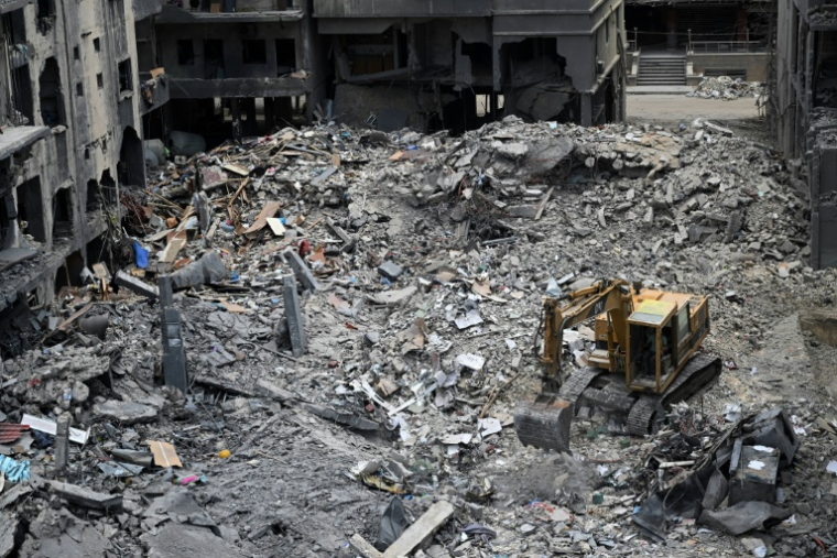 Des ouvriers déblaient avec une pelleteuse les décombres d'un bâtiment par une précédente frappe militaire israélienne sur un quartier de Tyr, dans le sud du Liban, le 23 juin 2026 ( AFP / Joseph EID )