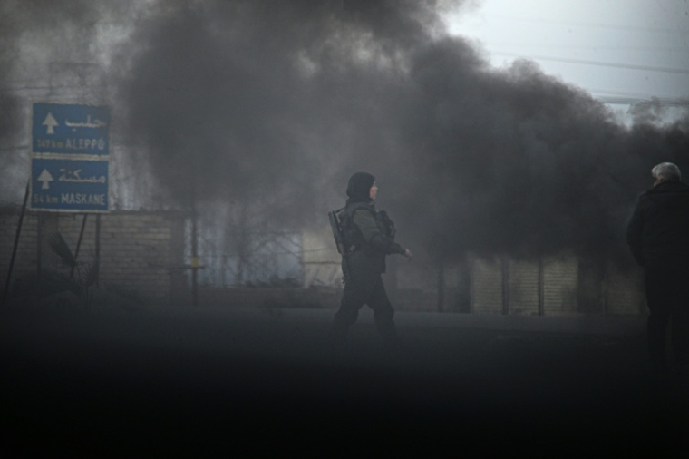 Un combattant kurde à l'entrée de la ville de Tabqa avant sa reprise par les forces de Damas, le 17 janvier 2026 ( AFP / Delil SOULEIMAN )
