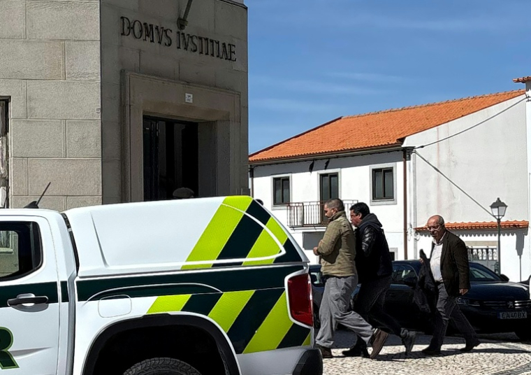 PLa police escorte l'ex-policier français Cedric Prizzon (g), soupçonné de double homicide et d'enlèvement, jusqu'au palais de justice de Vila Nova de Foz Coa, Guarda, dans le nord-est du Portugal, le 26 mars 2026 ( AFP / Levi FERNANDES )