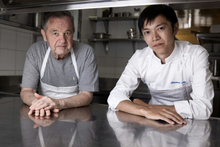 Le chef Bernard Pacaud (g) et son successeur, le chef japonais Shintaro Awa, dans les cuisines du restaurant l'Ambroisie, le 3 juillet 2025 à Paris ( AFP / JOEL SAGET )
