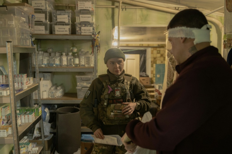 Anastassia Podobaïlo s'occupe d'un soldat blessé dans un poste médical de la 56e brigade, dans la région de Donetsk, le 15 mars 2026 en Ukraine ( AFP / Roman PILIPEY )