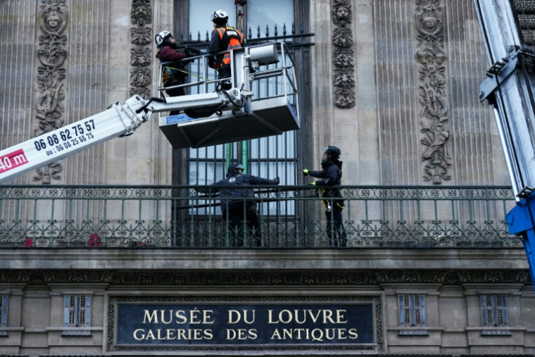 Des ouvriers installent une grille de protection devant la fenêtre de la galerie d'Apollon du  musée du Louvre, le 23 décembre 2025 à Paris ( AFP / Dimitar DILKOFF )
