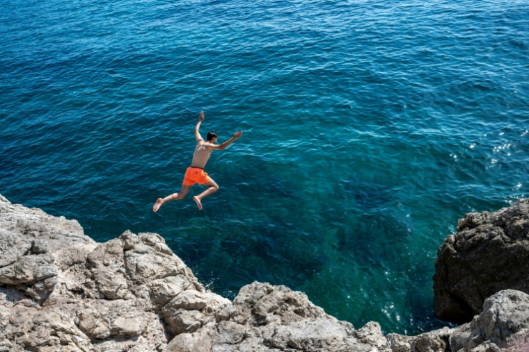 Un jeune saute de la corniche à Marseille le 11 août 2026 ( AFP / Miguel MEDINA )