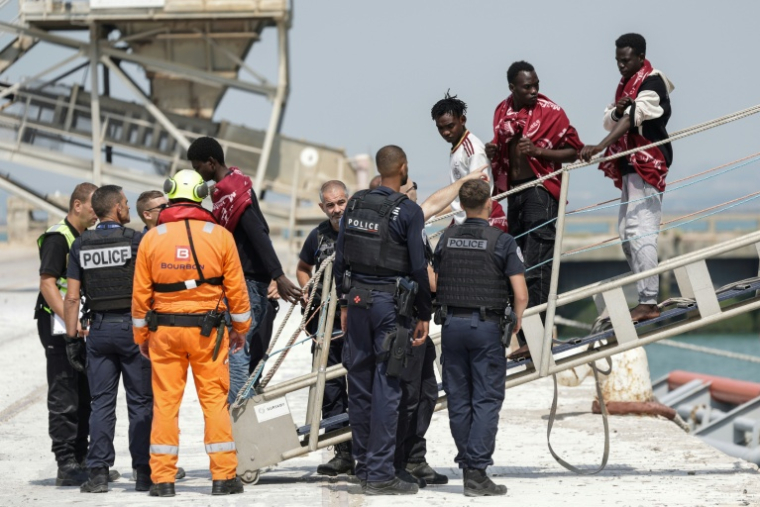 Des migrants débarquent du navire l'Argonaute au port de commerce de Boulogne-sur-Mer, le 4 août 2026 ( AFP / Sameer AL-DOUMY )