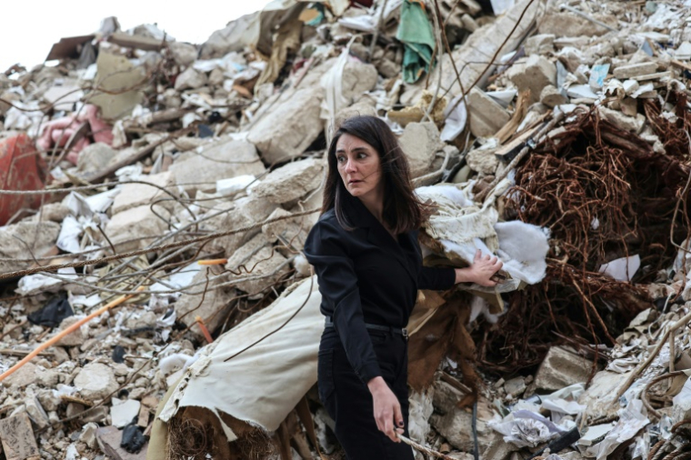 Ghida Krisht, qui a perdu ses parents dans une frappe israélienne contre leur immeuble, se tient au milieu des gravats du bâtiment, dans le quartier de Tallet el-Khayat, à Beyrouth, le 18 mai 2026 ( AFP / Anwar AMRO )
