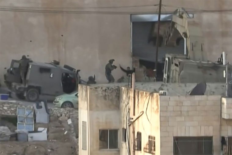 Image tirée d'une vidéo d'AFPTV, le 27 novembre 2025, montrant l'un des deux Palestiniens levant les mains apparemment en signe de reddition devant les forces israéliennes, quelques instants avant d'être abattu par des soldats lors d'une opération militaire à Jénine, en Cisjordanie occupée ( AFPTV / STRINGER )