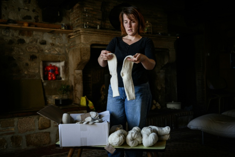 Chloé Pimont, une comédienne parisienne et végétarienne devenue éleveuse de brebis dans le Morvan, montre des chaussettes faites avec la laine de ses moutons, le 29 septembre 2025 à Monthelon, en Saône-et-Loire ( AFP / ARNAUD FINISTRE )