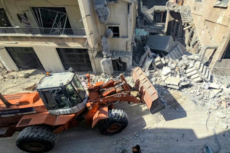 Un engin de chantier dégage les décombres de bâtiment détruits par des frappes israéliennes nocturnes sur la ville de Tyr, dans le sud du Liban, le 16 mai 2026  ( AFP / Kawnat HAJU )