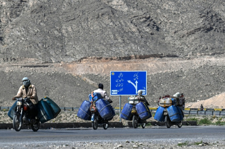 Des vendeurs transportent des bidons de carburant iraniens de contrebande, à la périphérie de Quetta, dans la province du Baloutchistan, le 14 mars 2026 au Pakistan ( AFP / Banaras KHAN )