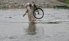 Un homme traverse une rue inondée de Karachi, mégapole du Pakistan où les pluies de mousson ont fait plus de 400 morts en une semaine, le 20 août 2025 ( AFP / Rizwan TABASSUM )