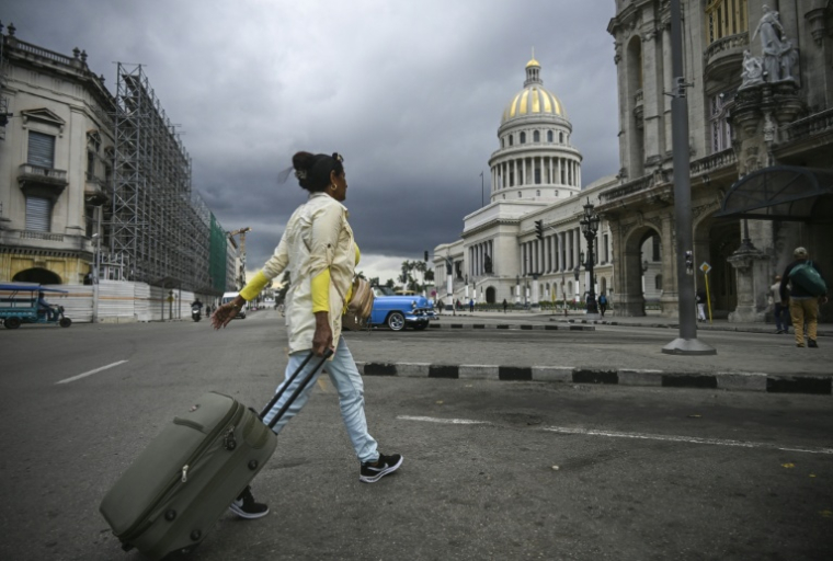 Une femme roule une valise près du Capitole, le 26 janvier 2026 à La Havanne  ( AFP / YAMIL LAGE )
