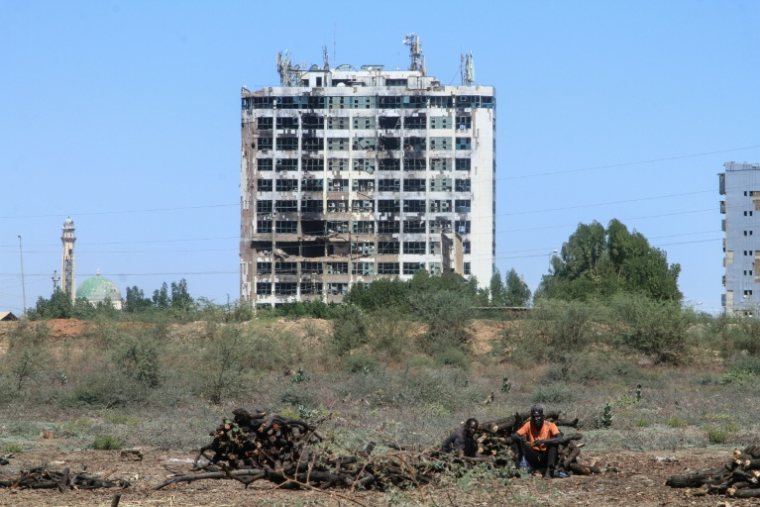 Un Soudanais assis près de bûches de bois à Khartoum, le 7 février 2026 ( AFP / Ebrahim Hamid )