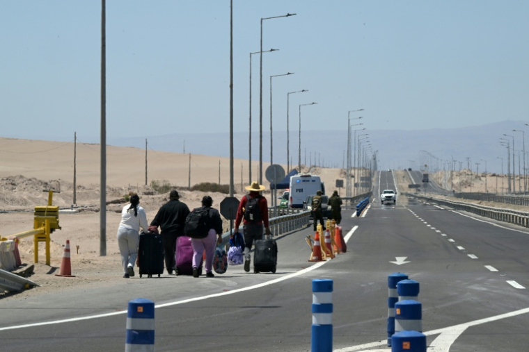 Des migrants retournent à pied au Chili après s'être vu refuser l'entrée au Pérou, près du poste frontière de Cachalluta, à environ 25 km au nord d'Arica, au Chili, le 30 novembre 2025 ( AFP / Rodrigo ARANGUA )