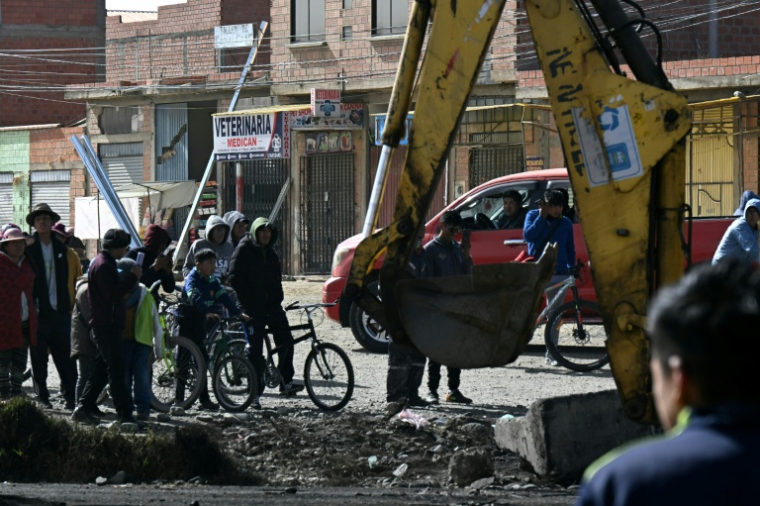 Un engin de chantier démolit une barricade dans une zone de blocage à El Alto, après que le président Rodrigo Paz a déclaré l'état d'urgence, le 20 juin 2026 à en Bolivie ( AFP / AIZAR RALDES )