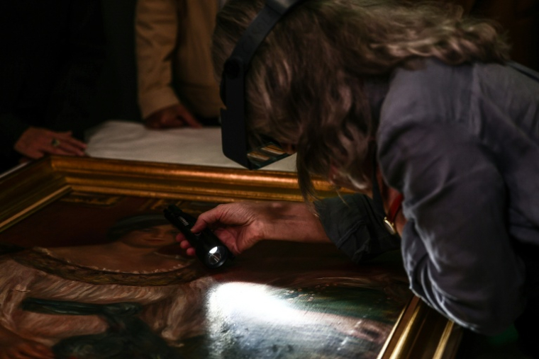 Une restauratrice montre une déchirure dans le tableau "Portrait de Madame Colonna" de Pierre-Auguste Renoir, le 12 octobre 2026 à Marseille ( AFP / Thibaud MORITZ )