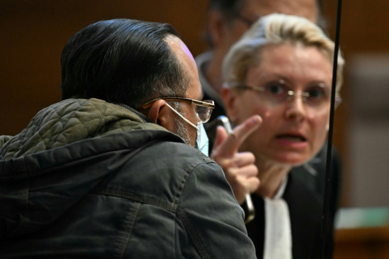 DeL'accusé Husamettin Dogan (g) avec ses avocats lors du procès en appel des viols de Mazan au palais de justice de Nîmes, le 6 octobre 2025 dans le Gard ( AFP / Gabriel BOUYS )