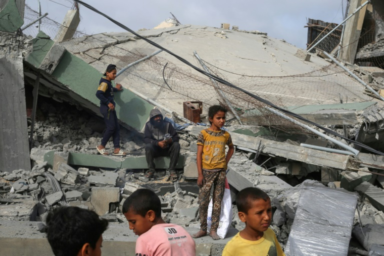 Des Palestiniens observent les décombres de la mosquée Al-Hassanat après un bombardement israélien, dans le camp de réfugiés de Nousseirat, au centre de la bande de Gaza, le 12 mai 2025 ( AFP / Eyad BABA )