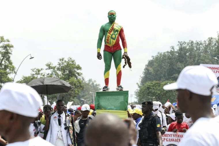 Un partisan du président congolais sortant et candidat à sa réélection Denis Sassou Nguesso se tient sur une estrade lors d'un meeting de campagne à Brazzaville, le 13 mars 2026 ( AFP / Daniel BELOUMOU OLOMO )