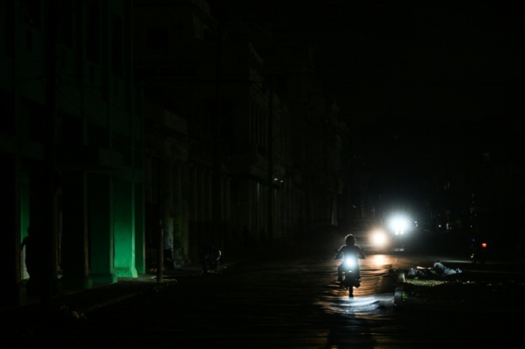 Une personne circule à moto dans une rue pendant une panne de courant à La Havane, la capitale cubaine, le 25 janvier 2026. ( AFP / YAMIL LAGE )