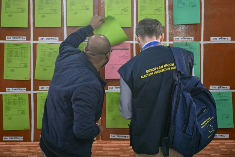 Des membres des médias consultent des documents sur les résultats préliminaires des élections législatives au bureau de la Commission électorale à Dacca, le 13 février 2026 au Bangladesh ( AFP / MOHD RASFAN )