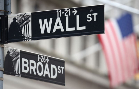 Un panneau de Wall Street devant un drapeau américain à l'extérieur du New York Stock Exchange (NYSE)