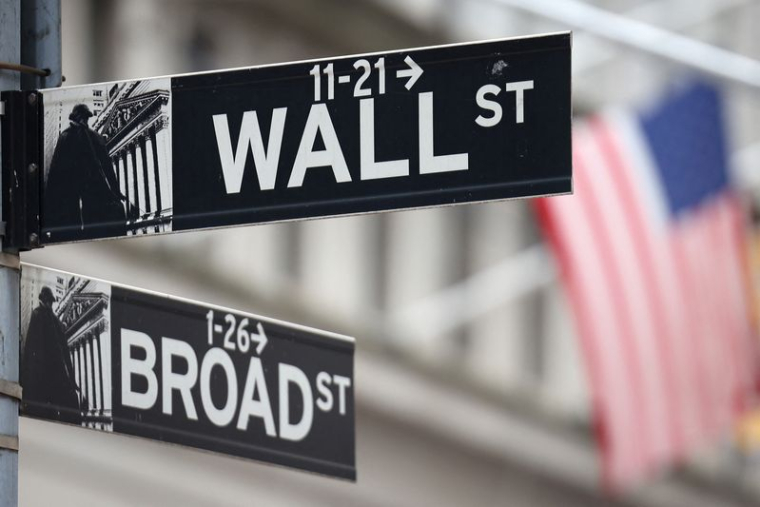 Un panneau de Wall Street devant un drapeau américain à l'extérieur du New York Stock Exchange (NYSE)