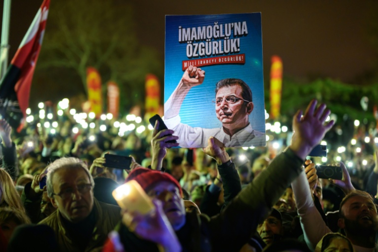 Manifestation à Istanbul à l'occasion du premier anniversaire de la mise en détention du maire Ekrem Imamoglu, dont le portrait figure sur une affiche, le 18 mars 2026 ( AFP / Yasin AKGUL )