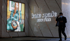 Un homme passe devant un magasin Kate Spade dans un quartier commerçant de Pékin