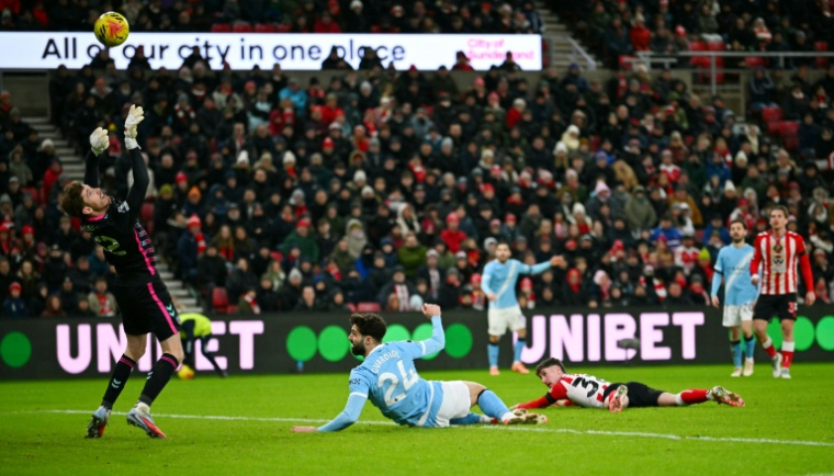 Le gardien de Sunderland Robin Roefs (à gauche) dégage une frappe de la tête de Josko Gvardiol (au centre) lors du match de Premier League contre Manchester City le 1er janvier 2026 à Sunderland ( AFP / ANDY BUCHANAN )