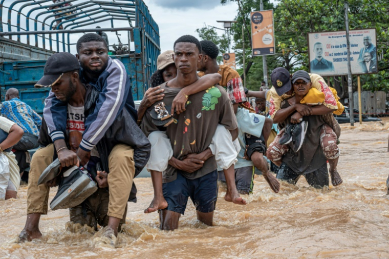 Des habitants dans un quartier inondé à Kinshasa, après des pluies diluviennes, le 6 avril 2025 en RDC ( AFP / Hardy BOPE )