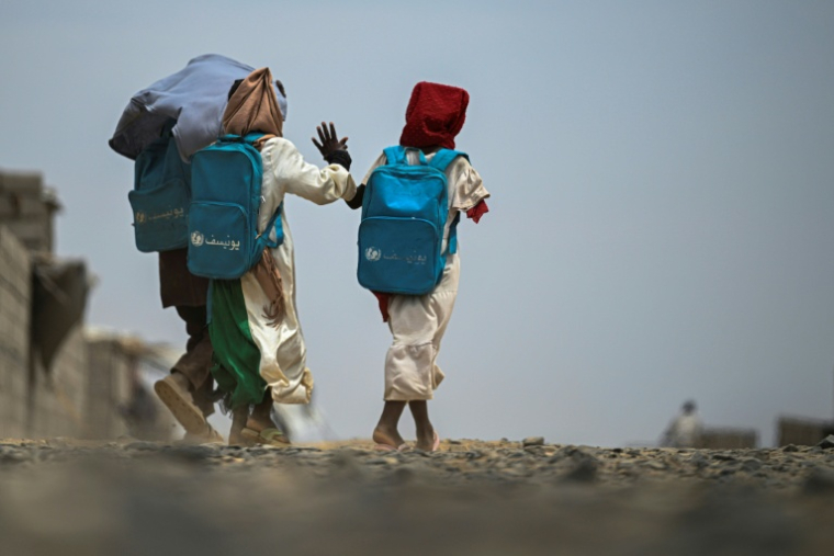 Une fillette, amputée de son bras droit après avoir été blessée pendant la guerre, sort de l'école gérée en partenariat avec l'Unicef dans un camp de personnes déplacées, près de Port-Soudan, le 26 avril 2026 au Soudan ( AFP / Khaled DESOUKI )