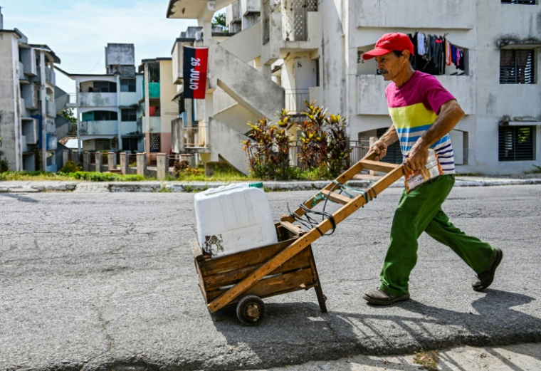 Un Cubain transporte un bidon d'eau potable à Pinar del Rio, Cuba, le 25 juillet 2026 ( AFP / YAMIL LAGE )