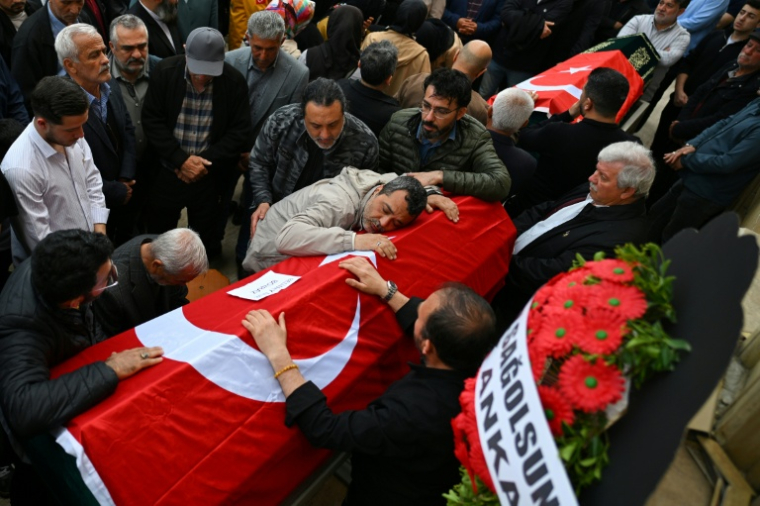 Les familles et les personnes en deuil se rassemblaient autour des cercueils recouverts du drapeau turc. ( AFP / YASIN AKGUL )