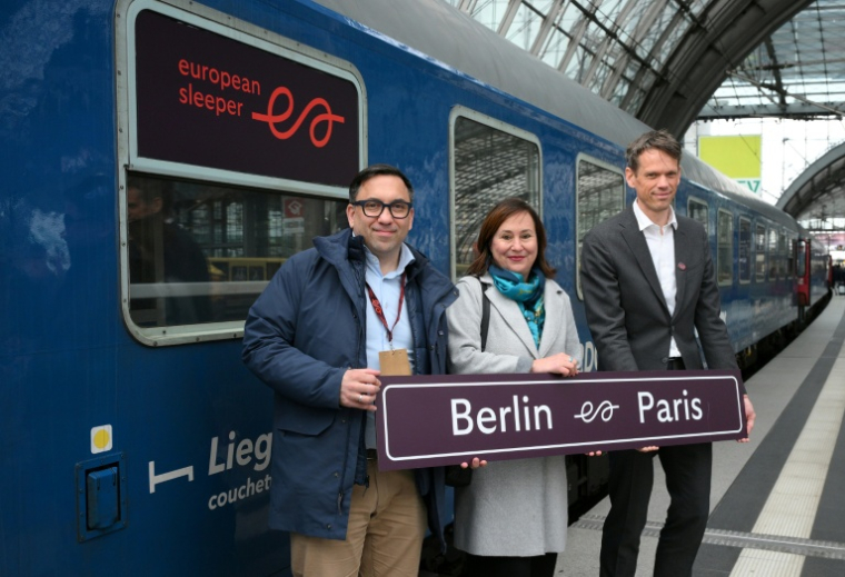 Elmer van Buuren (g) et Chris Engelsman (d), cofondateurs d’"European Sleeper", et Sabine Wendt, directrice générale de "visit Berlin", après l’arrivée du train de nuit European Sleeper en provenance de Paris, le 27 mars 2026 à Berlin ( AFP / RALF HIRSCHBERGER )