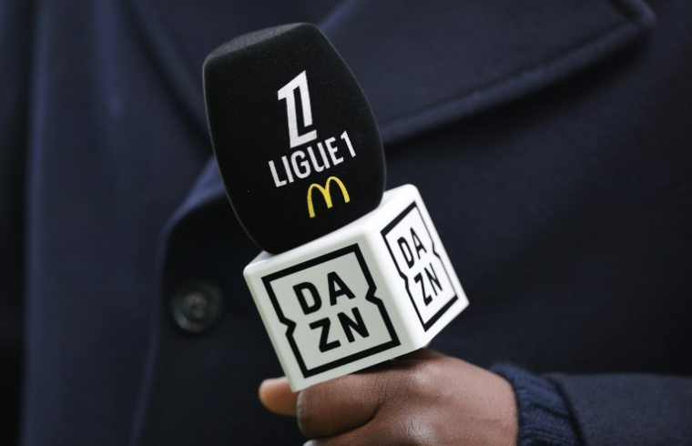 Logos de la Ligue 1 et du diffuseur DAZN sur un micro, le 23 février 2025 au stade de la Beaujoire, à Nantes ( AFP / FRED TANNEAU )