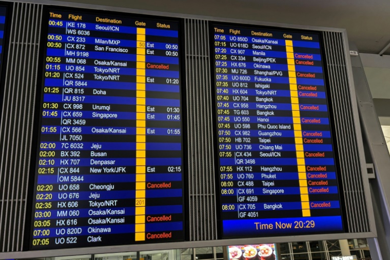 Ecran montrant des vols annulés à l'aéroport de Hong Kong à cause d'une alerte au typhon, le 19 juillet 2025 ( AFP / Dene-Hern CHEN )